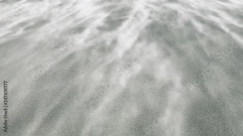 Sand blowing on a beach in slow mothion photo