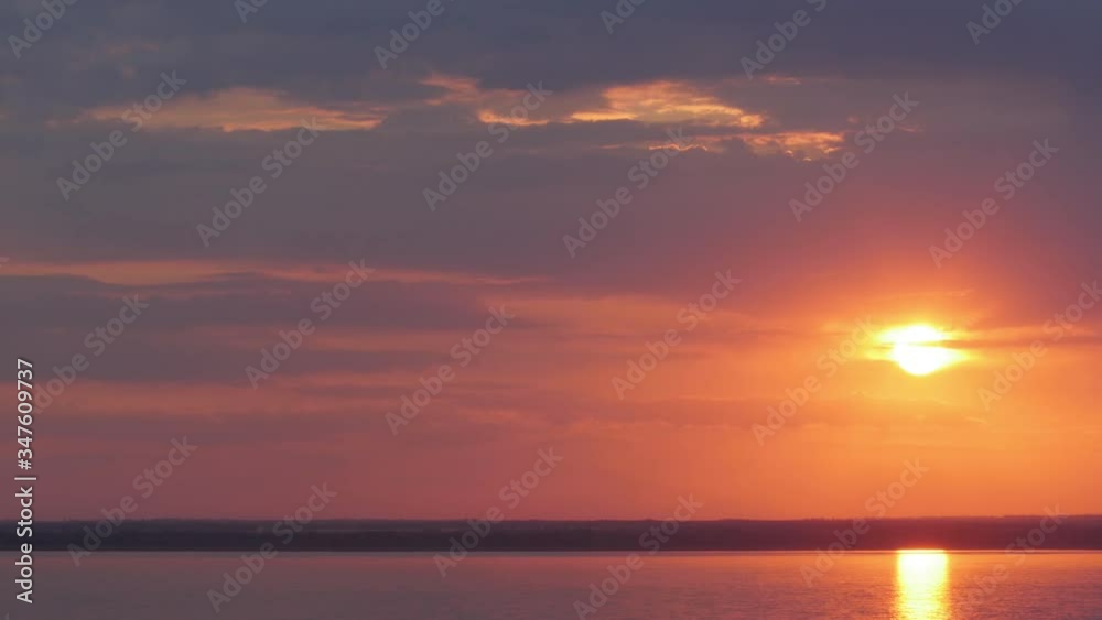 red-violet sunset with light clouds lit by the rays of the sun and floating water red-violet sunset with light clouds lit by the rays of the sun and floating water