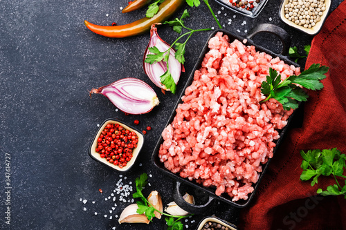 Mince, ground minced meat with ingredients for cooking on black background. Top view, copy space