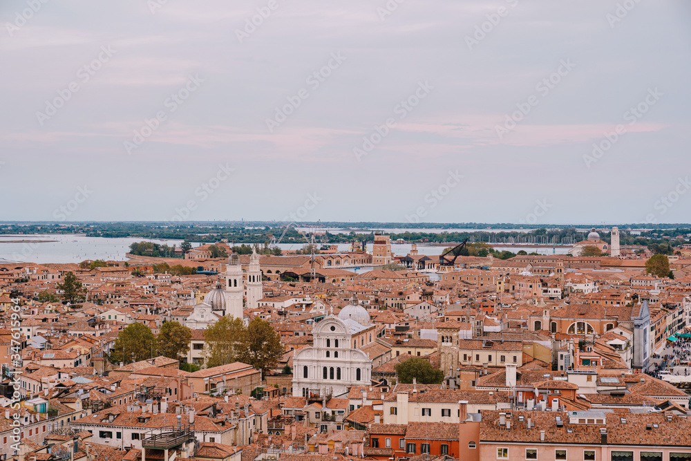 Aerial view from huge cathedral bell tower San Marco Campanile of the Church of San Zaccaria and San Giorgio dei Greci and on the orange shingles on the roofs of buildings. Venice, Italy 