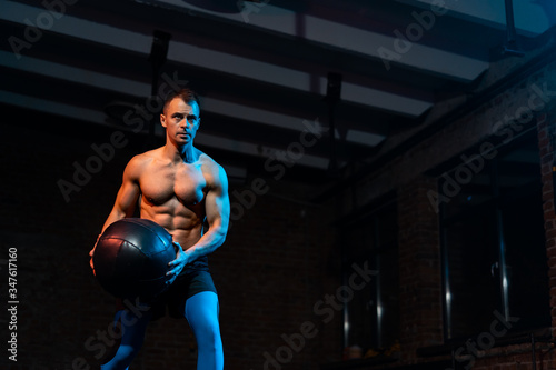 Shirtless fit young man working out in dark fitness studio © Marcel Poncu