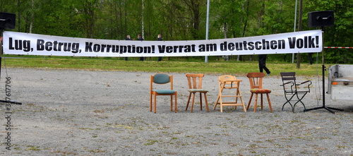 Protest-Transparent mit der Aufschrift: Lug, Betrug, Korruption! Verrat am deutschen Volk! Darunter fünf leere Stühle photo