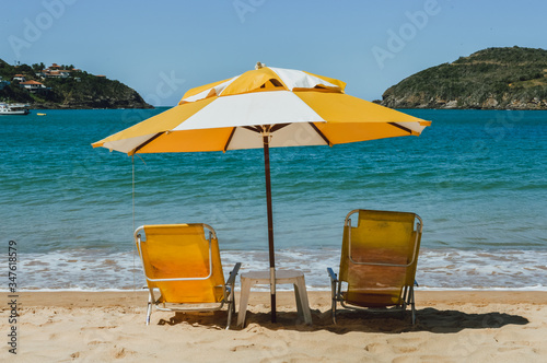 umbrellas and empty deck chairs on a paradise beach
