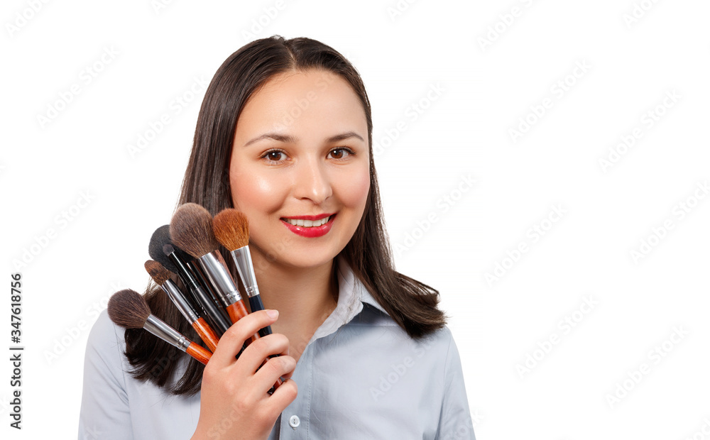 a female makeup artist with a set of makeup brushes looks at the camera and smiles. isolated on a white background. a female makeup artist with a set of makeup brushes looks at the camera and smiles. isolated on a white background.