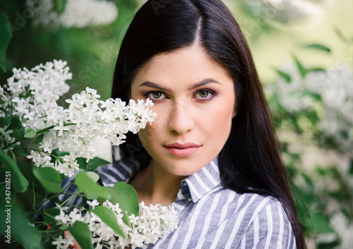 Obraz na plátně Portrait of a beautiful brunette whith a flowering tree