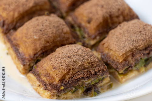 Turkish close up baklava with cocoa and milk on white plate