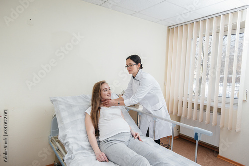 The doctor advises and serves a young pregnant girl in a medical clinic. Medical examination © Andrii