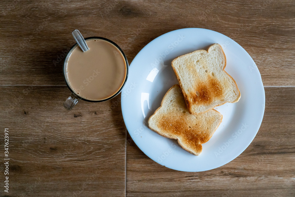 Cup of coffe with milk and two slices of toasted sandwich bread on a white plate. Healthy breakfast with coffee. Top view. Free space for text.