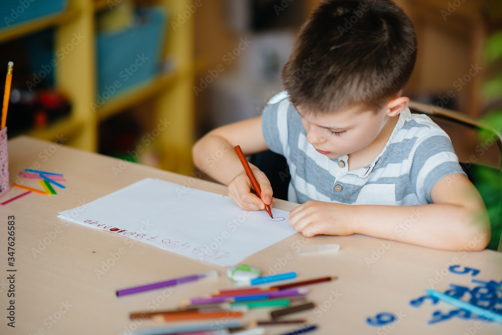 A school-age boy does homework at home. Training at school A school-age boy does homework at home. Training at school