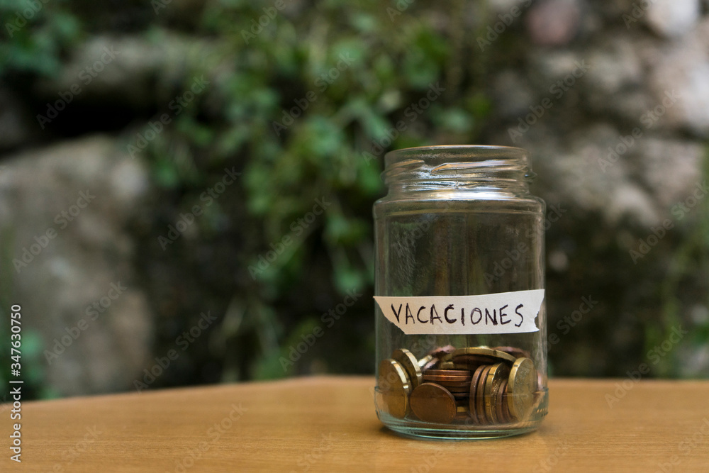 A glass jar with coins inside and a A glass jar with coins inside and a
