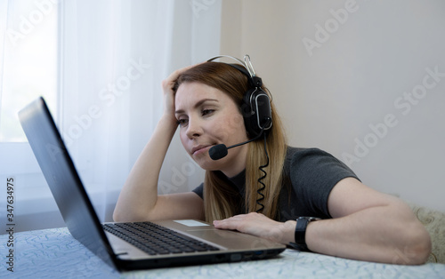 stressed elegant learner woman in room in sunny day study online on a laptop