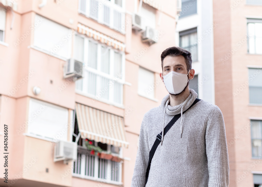 Young man with facial mask taking a walk in the city. New normal life style