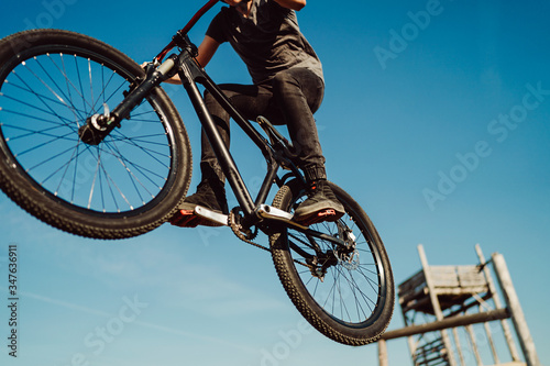 Mountain biker flying through the air after jumping off a ramp