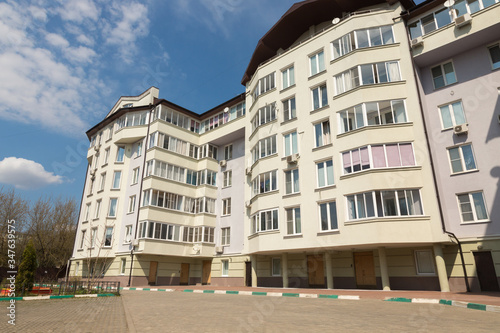 Photography Modern apartment building is on a background of blue sky at sunny day