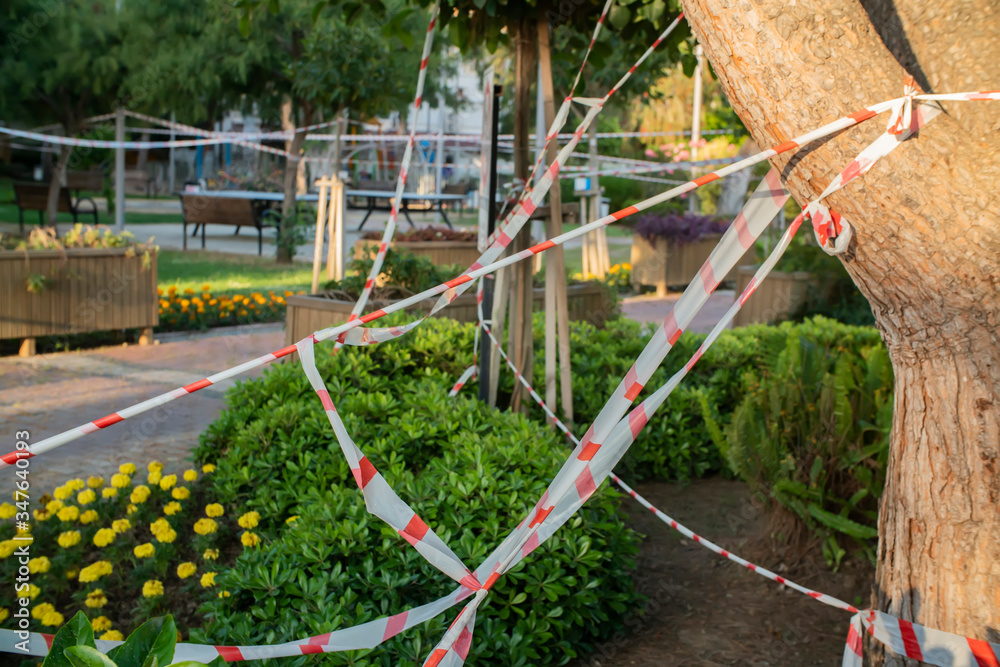 Fototapeta premium Barrier tape - quarantine, isolation, entry ban. Do not cross on the park