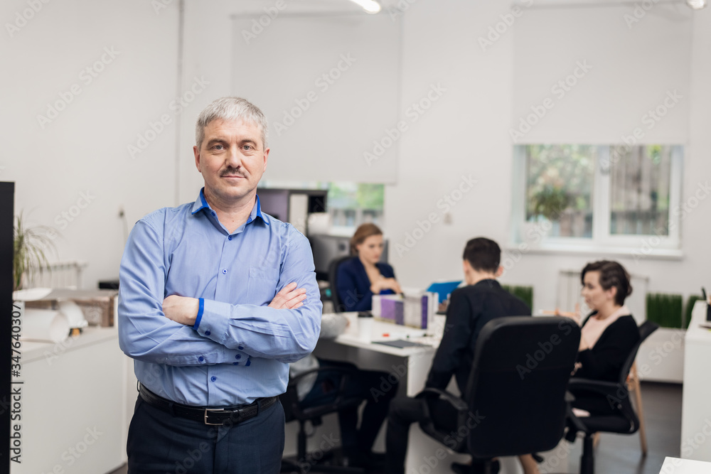 A portrait of a cheerful, grey-haired senior businessman standin A portrait of a cheerful, grey-haired senior businessman standin