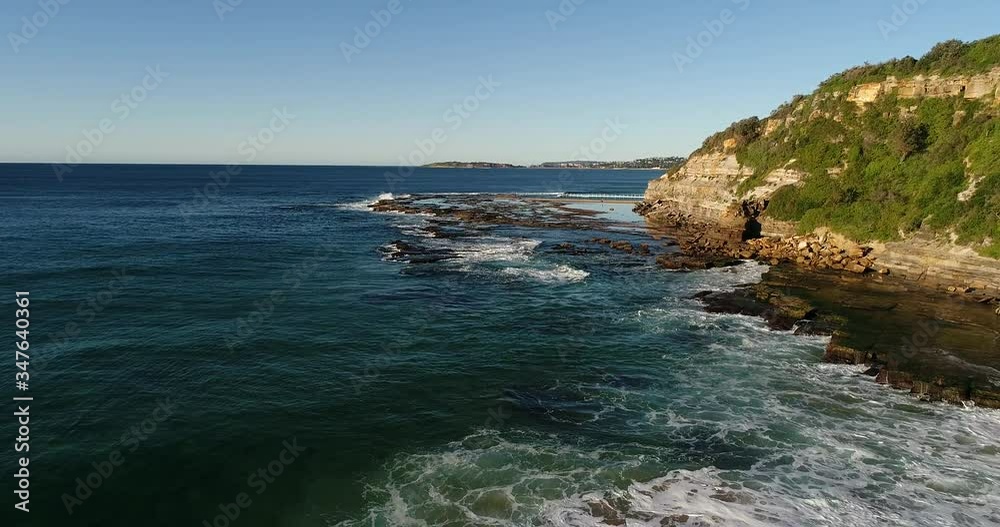 Narrabeen head and sandstone plateau towards rock pool over ocean wave in aerial flying.
Narrabeen head and sandstone plateau towards rock pool over ocean wave in aerial flying.