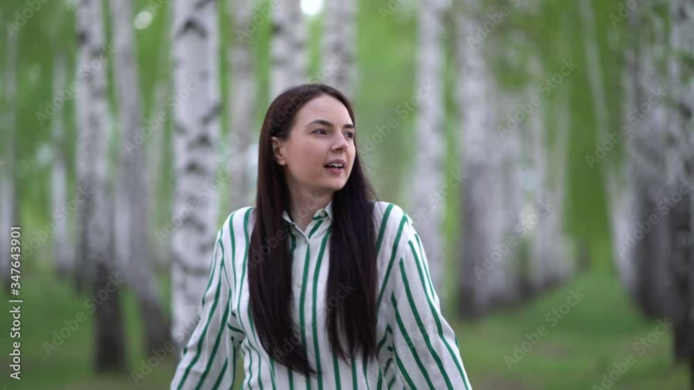 Young woman takes off medical mask and takes a deep breath in the birch grove. Young woman takes off medical mask and takes a deep breath in the birch grove.