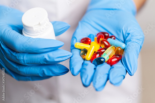 Female doctor in gloves holds a pill for treatment