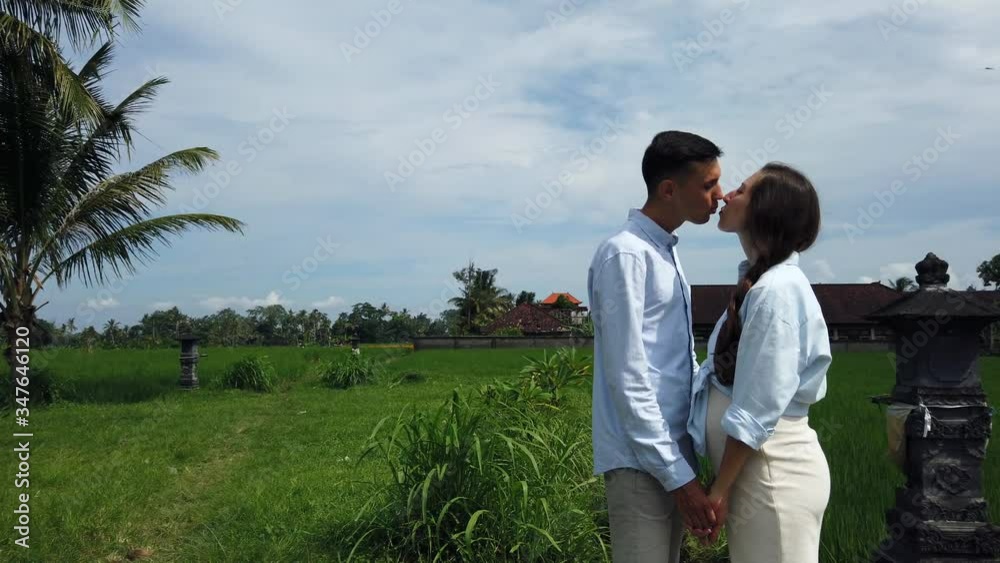Romantic love story. Beautiful family couple, man and pregnant wife posing, holding hands kissing and looking into each others eyes in rice terraces, Bali, Indonesia. Romantic love story on nature Romantic love story. Beautiful family couple, man and pregnant wife posing, holding hands kissing and looking into each others eyes in rice terraces, Bali, Indonesia. Romantic love story on nature
