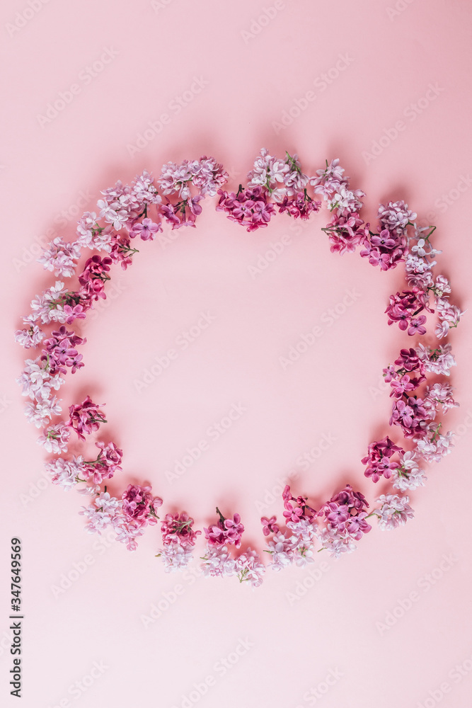 Floral pattern made of lilac flowers on pink background. Flat lay. Floral purple frame