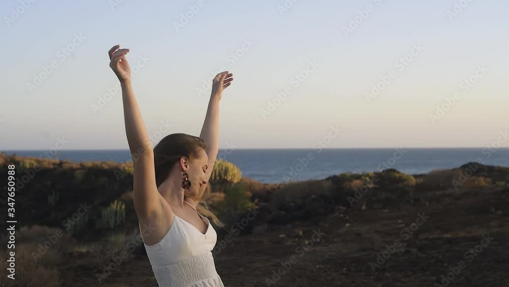 The girl dances in the mountains, against the backdrop of the ocean and the tourist city. Gorgeous brown-haired woman with long hair dancing, music video, summer. Sunset on the island. The girl dances in the mountains, against the backdrop of the ocean and the tourist city. Gorgeous brown-haired woman with long hair dancing, music video, summer. Sunset on the island.