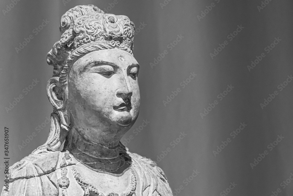 Black and white photo showing face of asian statue