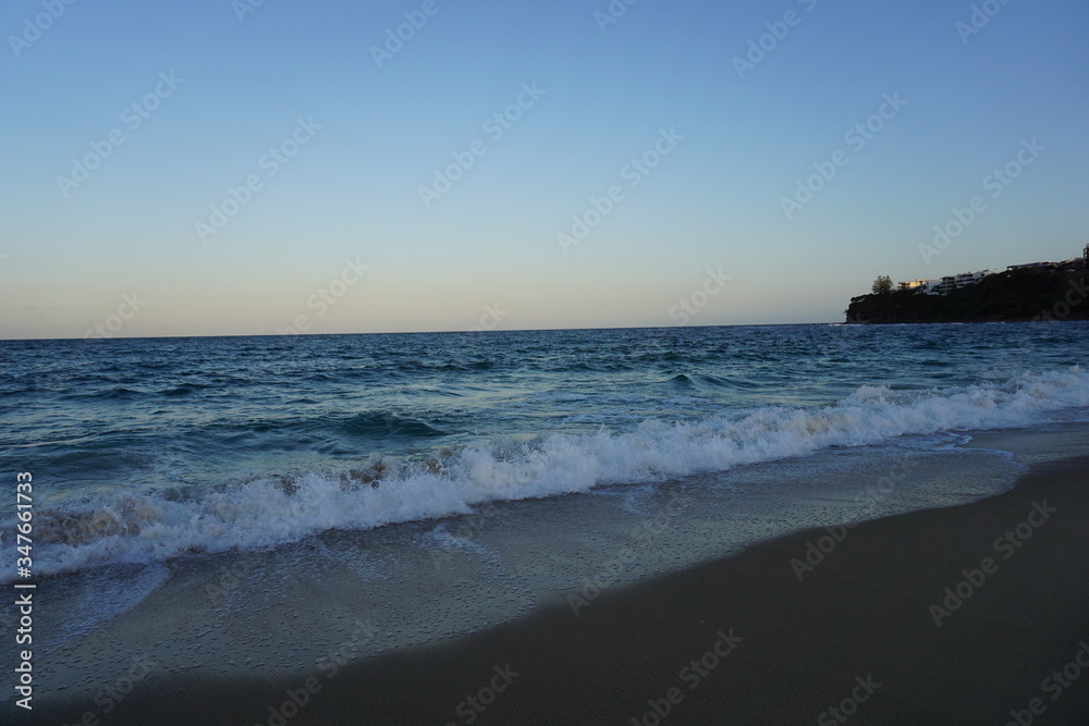 Australian sunset beach, waves, blue sky and sand.