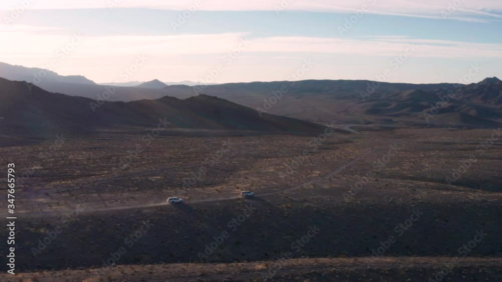 Two SUVs drive through the desert east of Tecopa, CA. The Amargosa River Valley and Avawatz Mountains are seen in the background. Two SUVs drive through the desert east of Tecopa, CA. The Amargosa River Valley and Avawatz Mountains are seen in the background.