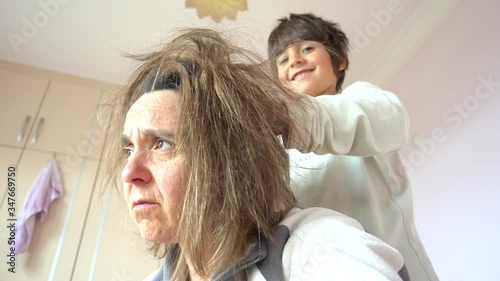 Fethiye, Turkey - 12h of May, 2020: 4K Lockdown meltdown Selfie - Child combs shaggy hair of his apathic mother
