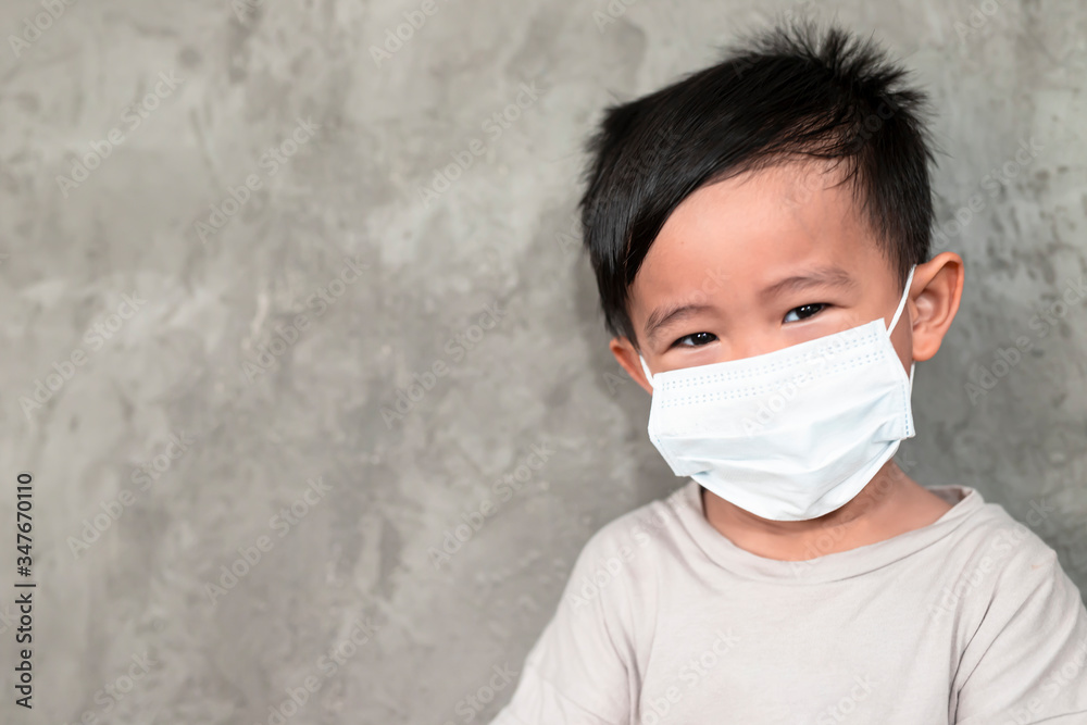 A boy wearing medical face mask for pollution or coronavirus,child itchy eyes and nose, Kid scratching nose while wearing protection mask.Protection against contagious disease, coronavirus.