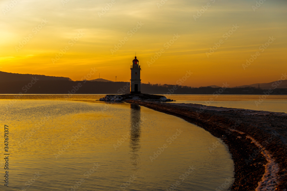 Dawn in the sea city of Vladivostok. Tokarevsky lighthouse during a colorful dawn against the backdrop of a beautiful sea.