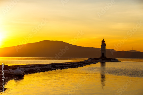 Dawn in the sea city of Vladivostok. Tokarevsky lighthouse during a colorful dawn against the backdrop of a beautiful sea.
