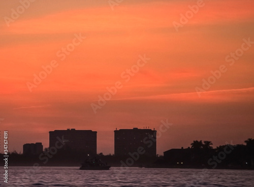 sunset over the city, sky, skyline, silhouette, clouds, vibrant, colorful, red, urban, horizon, building © Renee