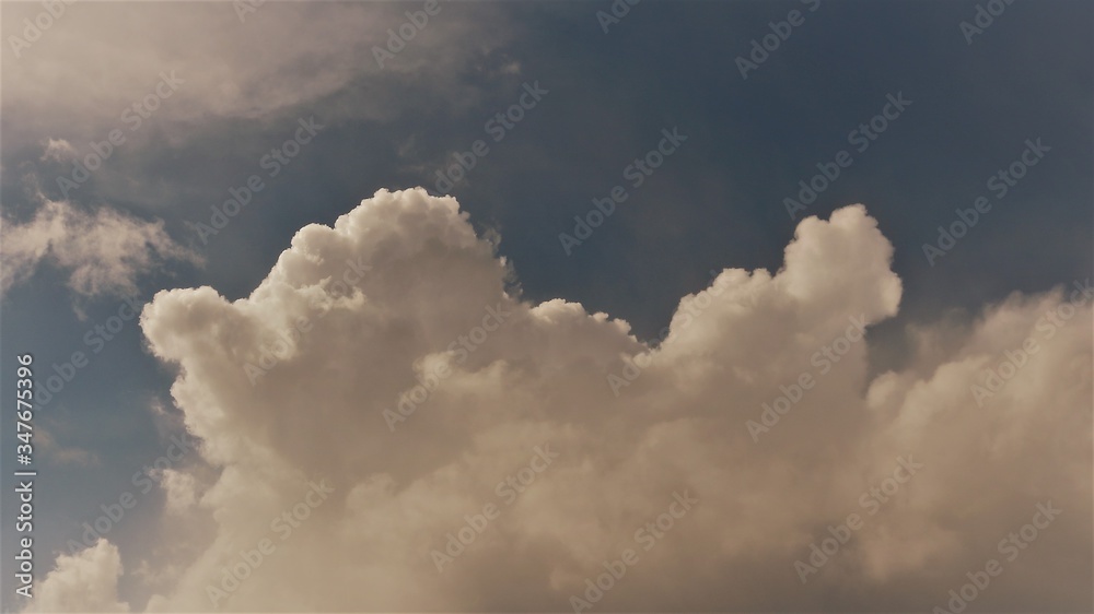 volumetric cumulus cloud lit by the sun on a dim blue sky volumetric cumulus cloud lit by the sun on a dim blue sky