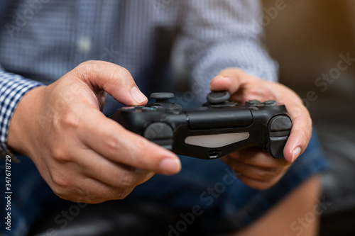 Close up hands of man holding console playing the video game at home.playful enjoyment view concept.