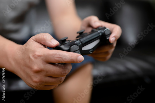 Close up hands of man holding console playing the video game at home.playful enjoyment view concept.