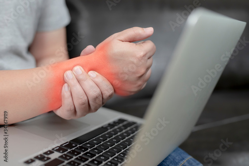 A young man with pain in his hand because of hard work, Ache in human body , office syndrome,Bone and joint disease, Concept healthcare and medical.