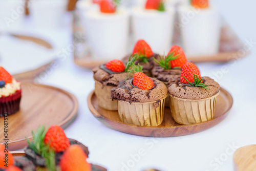 Chocolate cupcakes with fresh strawberry on white table