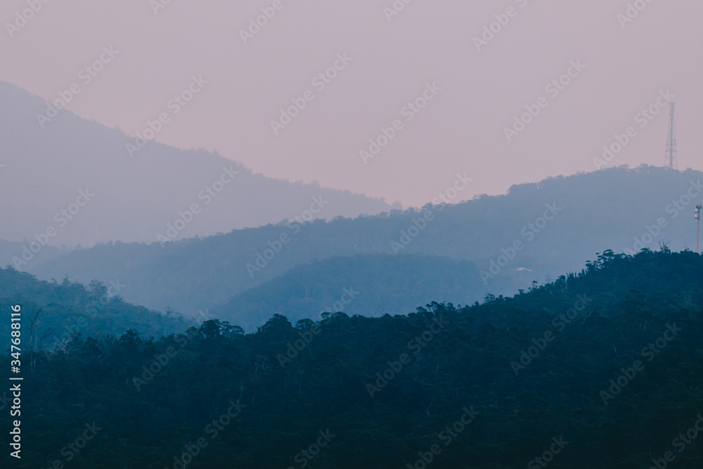 Obraz premium blue hour over the mountains in Tasmania with different layers of mountain ranges in the distance