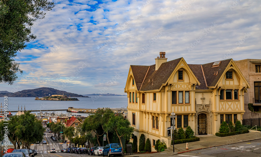 Cable car tracks atop Hyde Street next to a Tudor house, with the famous Alcatraz prison island in background in San Francisco, California USA Cable car tracks atop Hyde Street next to a Tudor house, with the famous Alcatraz prison island in background in San Francisco, California USA
