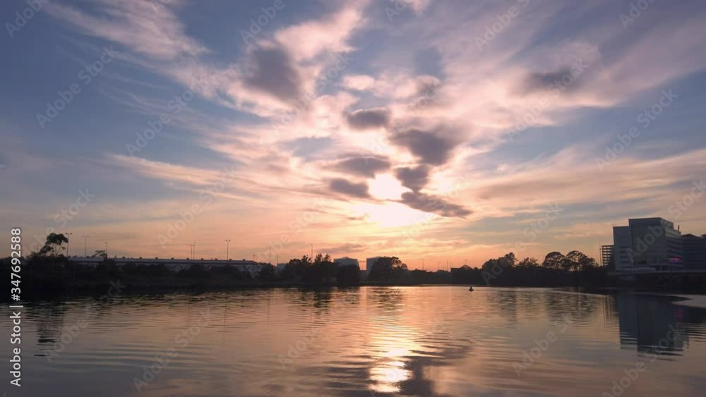 Amazing sunrise over a calm river. Yellow sun over water with orange and red reflections. Beautiful serene nature background scene with morning sunlight reflect on water surface. Amazing sunrise over a calm river. Yellow sun over water with orange and red reflections. Beautiful serene nature background scene with morning sunlight reflect on water surface.