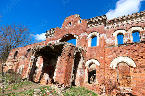 Main entrance of the ruined abandoned castle estate of baron Vrangel in Russia at sunny spring day photo