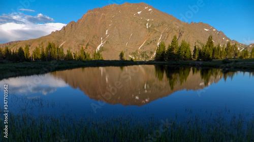 High mountain lake reflecting jagged peaks © Caleb
