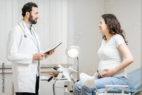 Doctor with pregnant woman during a medical consultation in gynecological office. Concept of medical care and health during a pregnancy