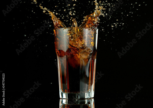 Splashing cola drink on black background