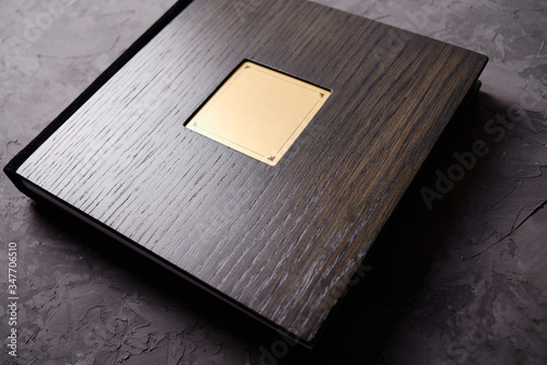 Wood brown wedding photobook on dark concrete background, copy space. Mockup template