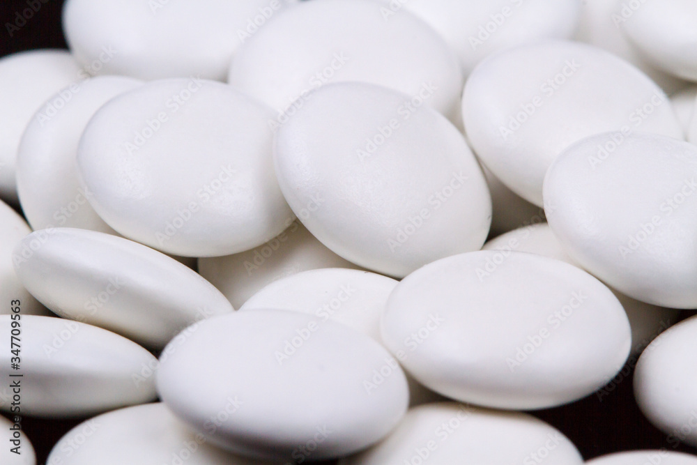 White pills on a dark background. Subject macro photography. White pills on a dark background. Subject macro photography.