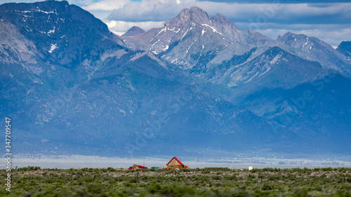 фотографія Lonely cabin under the immensity of a looming mountain