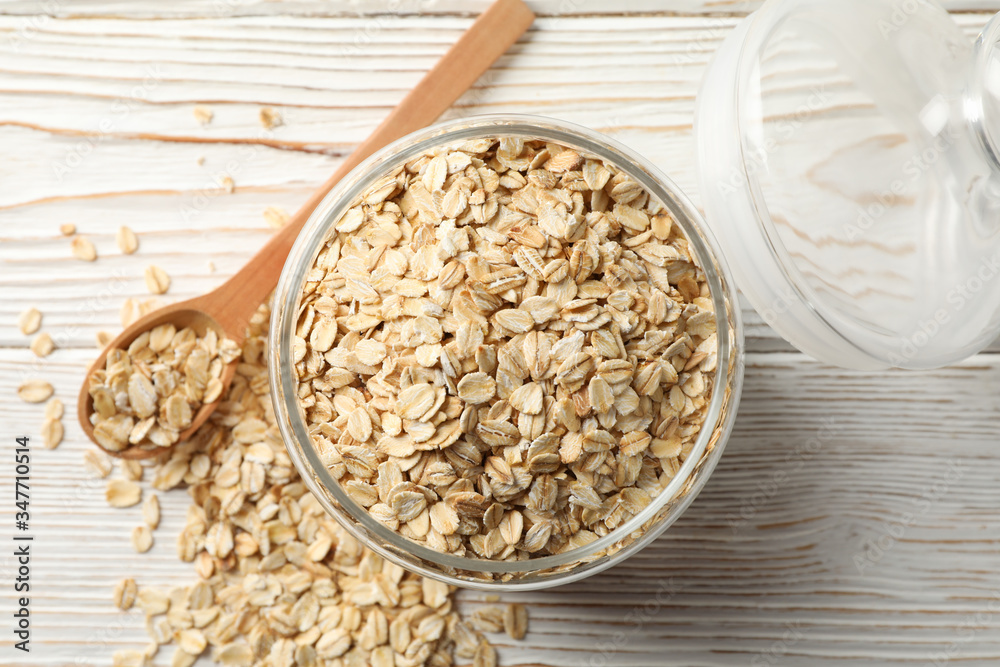 Glass jar with oatmeal and spoon on wooden background, top view Glass jar with oatmeal and spoon on wooden background, top view